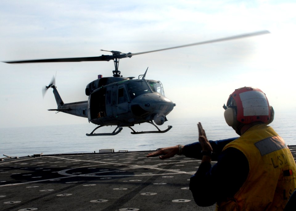 US Navy 100215-N-2000D-079 Seaman William Burns, from Spring, Texas, directs a UH-1N Huey helicopter during flight quarters aboard the amphibious dock landing ship USS Carter Hall (LSD 50)