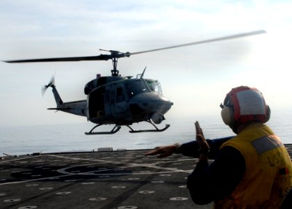 US Navy 100215-N-2000D-079 Seaman William Burns, from Spring, Texas, directs a UH-1N Huey helicopter during flight quarters aboard the amphibious dock landing ship USS Carter Hall (LSD 50)