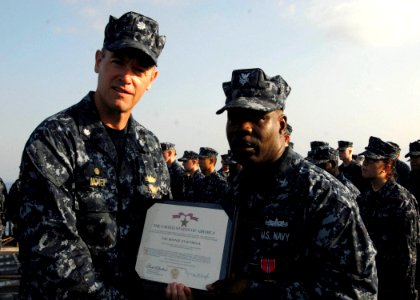 US Navy 100217-N-7638K-141 Cmdr. Nate Moyer and Operations Specialist 1st Class Anthony Ford, from Baltimore, Md., pose for a photo after Ford was awarded a Bronze Star Medal
