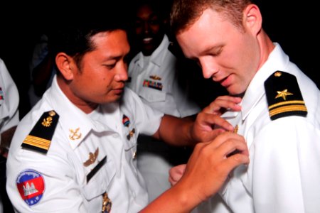 US Navy 100215-N-8335D-388 Lt. Tim Monipisey, left, a Sailor with the Royal Cambodian navy, exchanges warfare pins with Lt. j.g. Bradley Feige