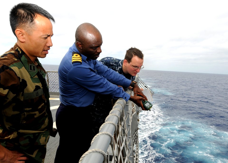 US Navy 100212-N-6676S-006 Lt. Brandon Le nd Aerographer's Mate 2nd Class Cory Clare look on as Nigerian navy Cmdr. Godffrey Kwetishe gathers sea surface temperature reading