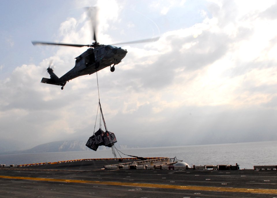 US Navy 100214-N-1092P-028 An MH-60S Sea Hawk helicopter from Helicopter Sea Combat Squadron (HSC) 22, delivers pallets of supplies to the multi-purpose amphibious assault ship USS Bataan (LHD 5)