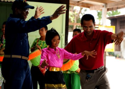 US Navy 100218-N-5538K-251 Chief Damage Controlman Troy C. Shinard participates in a traditional Rum Klong Yaw dance during a community service project