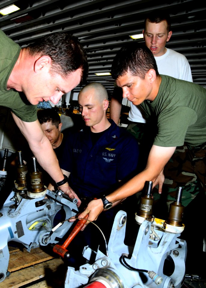 US Navy 100218-N-4649B-028 Sailors and Marines aboard USS Bataan (LHD 5) reassemble helicopter blade spindles in the ship's hangar bay