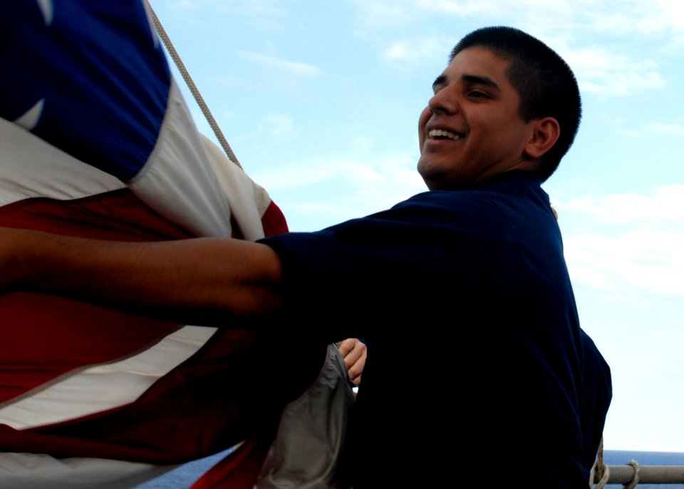 US Navy 100219-N-2000D-470 Quartermaster 3rd Class Perry Avila, from Lahabra, Calif., assigned to the amphibious dock landing ship USS Carter Hall (LSD 50), lowers the American flag after an underway refueling
