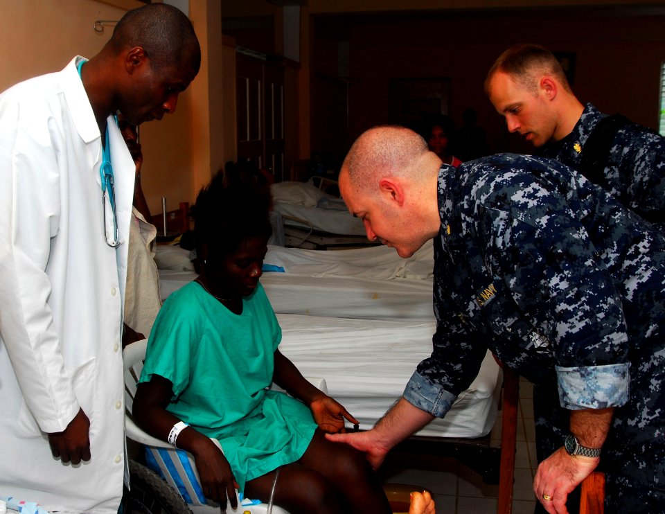 US Navy 100219-N-4047W-071 Cmdr. Sam Critides, from Glen Ridge, N.J., a neurosurgeon embarked aboard the Military Sealift Command hospital ship USNS Comfort (T-AH 20), performs a physical examination on a patient at St. Bonifac