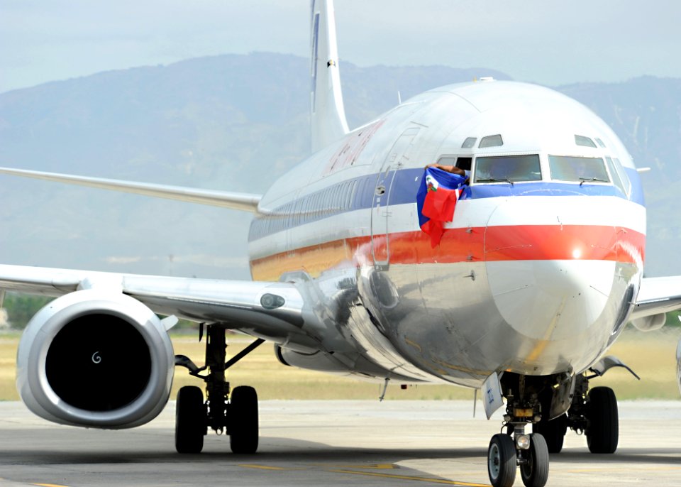 US Navy 100219-N-5961C-002 A pilot aboard an American Airlines flight from Miami waves a Haitian flag from the cockpit of his plane as it arrives at Toussaint Louverture International Airport in Port-au-Prince, Haiti
