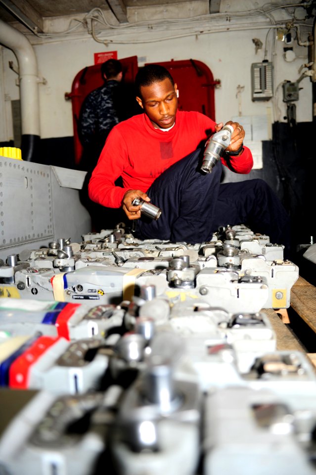 US Navy 100219-N-6604E-118 Aviation Ordnanceman 3rd Class Michael Martin inspects aircraft equipment in the hangar bay of the aircraft carrier USS Dwight D. Eisenhower (CVN 69)