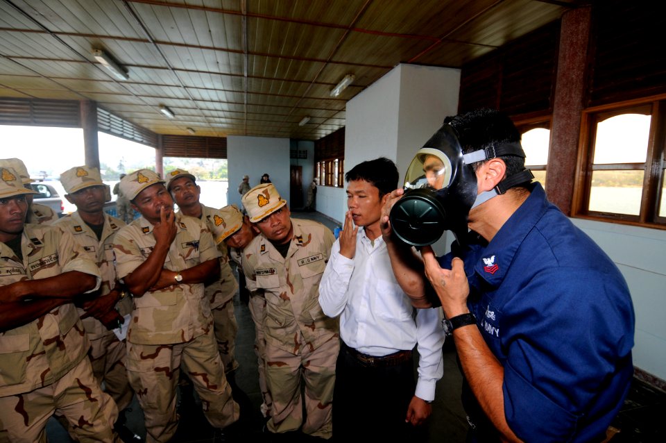 US Navy 100217-N-8335D-172 Damage Controlman 1st Class Arturo Chavez, assigned to the mine counter-measures ship USS Patriot (MCM 7), instructs Royal Cambodian Navy officers how to don an MCU-2P gas mask