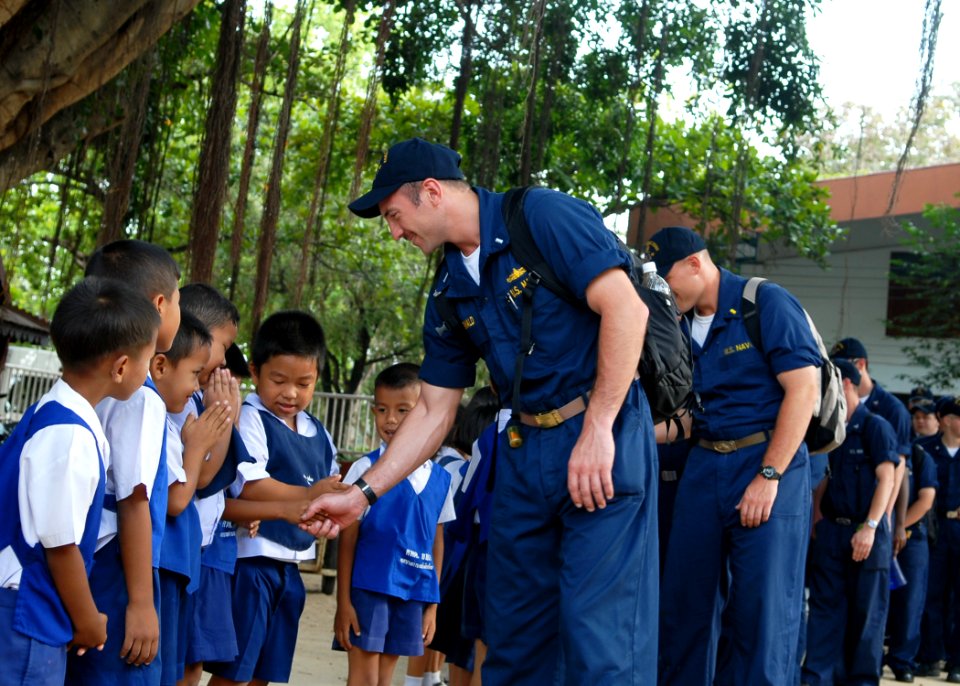 US Navy 100216-N-6692A-005 Sailors assigned to the amphibious dock landing ship USS Harpers Ferry (LSD 49) greet school children upon arrival at Bann Yai Ra Children Development Center during a Community service project