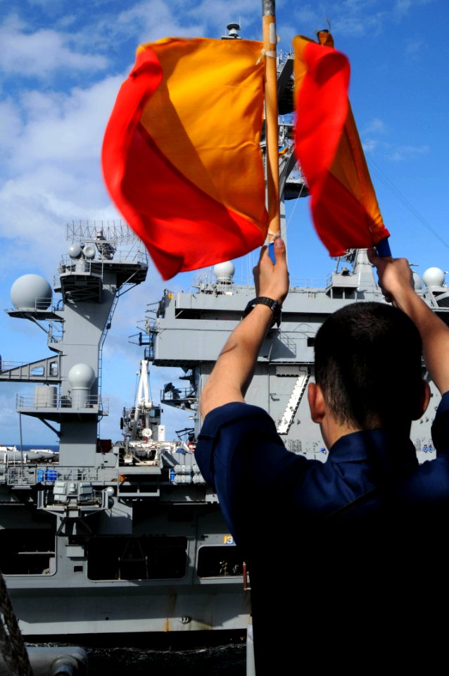 US Navy 100218-N-4275C-008 Quartermaster Seaman Matthew Rivera signals USS Carl Vinson (CVN 70) during a visual communications exercise aboard USS Bunker Hill (CG 52)