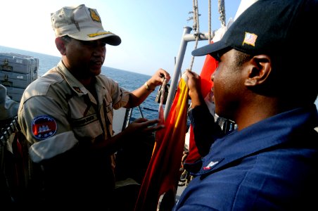 US Navy 100218-N-8335D-232 Quartermaster 3rd Class Jeremy Moore shows Lt. Chum Horn the man overboard Oscar flag aboard USS Patriot (MCM 7)