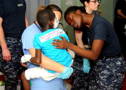 US Navy 100220-N-6410J-013 Hospital Corpsman 3rd Class Brittany Saulsberry, from Dallas, Texas, comforts a young boy before he receives medical treatment aboard the Military Sealift Command hospital ship USNS Comfort (T-AH 20)