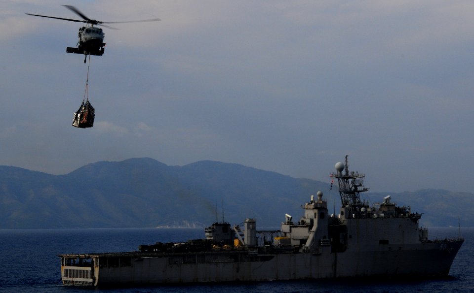 US Navy 100220-N-7508R-038 An MH-60S Sea Hawk approaches the multipurpose amphibious assault ship USS Bataan (LHD 5) after picking up cargo from the dock landing ship USS Carter Hall (LSD 50)