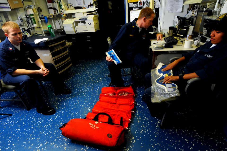 US Navy 100221-N-1688B-005 Chief Hospital Corpsman Edward Lennon helps Boatswain's Mate Seaman Rutchal Mandafe inventory a search and rescue medical kit aboard the guided-missile cruiser USS Hue City (CG 66)