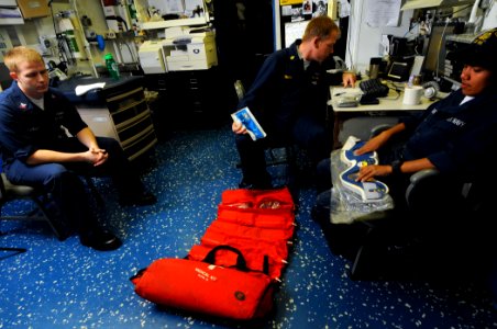 US Navy 100221-N-1688B-005 Chief Hospital Corpsman Edward Lennon helps Boatswain's Mate Seaman Rutchal Mandafe inventory a search and rescue medical kit aboard the guided-missile cruiser USS Hue City (CG 66)