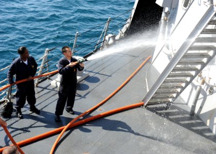 US Navy 100220-N-7088A-088 Damage Control Fireman Erin Lagos sprays down part of the Arleigh Burke-class guided-missile destroyer USS Farragut (DDG 99)