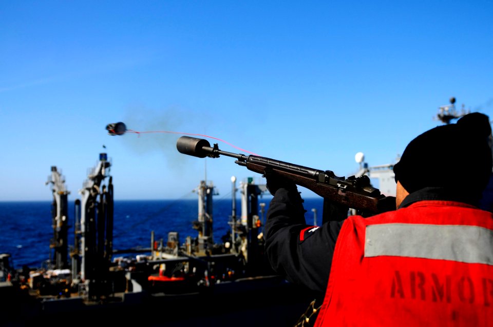 US Navy 100222-N-2735T-197 Aviation Ordnanceman 3rd Class Nathan Whitworth fires a line from the flight deck of USS Nassau (LHA 4)