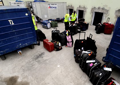 US Navy 100219-N-5961C-006 orkers at Toussaint Louverture International Airport in Port-au-Prince, Haiti unload luggage from an American Airlines flight