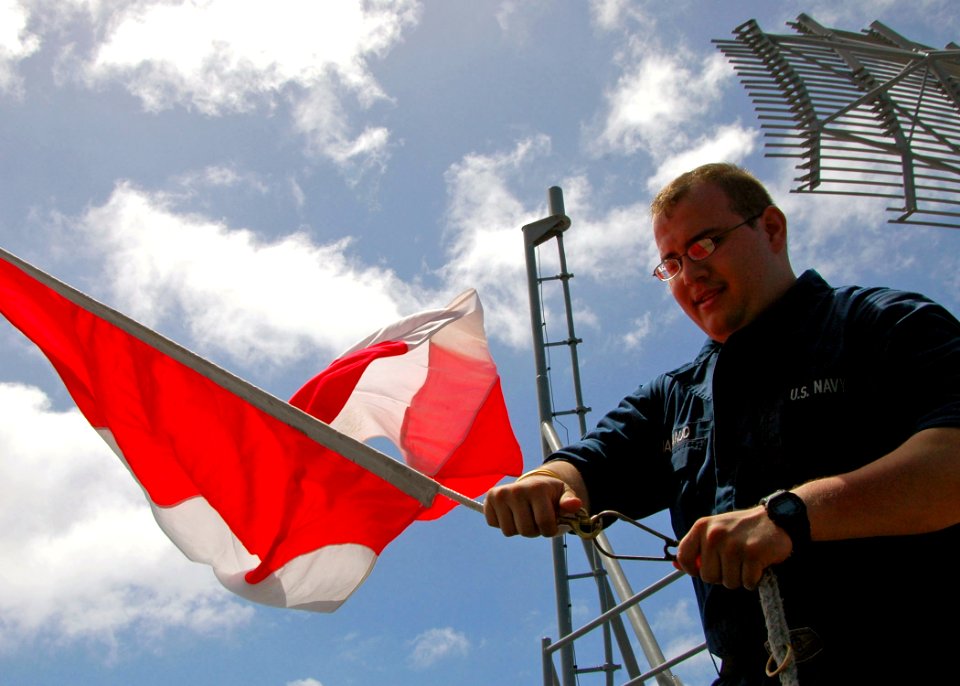 US Navy 100219-N-8822R-021 Quartermaster Seaman Apprentice Adam Naranjo hoists flags aboard USS Carl Vinson (CVN 70) during a visual communication drill with USS Bunker Hill (CG 52)