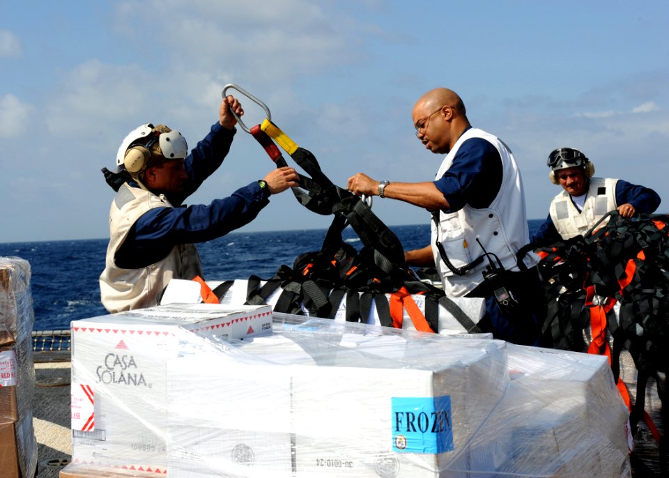 US Navy 100219-N-7088A-112 Command Master Chief C.J. Mitchell and Chief Aviation Structural Mechanic Mark Benino unpack supply pallets during a vertical replenishment at sea