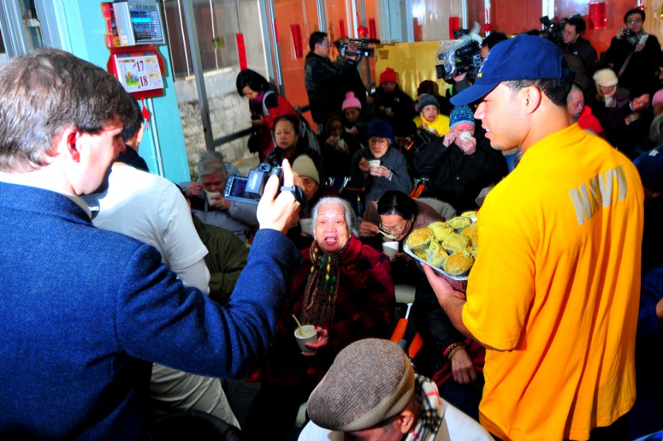 US Navy 100219-N-4053P-124 Aviation Electronics Technician Dominque Lawson, assigned to the aircraft carrier USS Nimitz (CVN 68), serves food during a community service project at a senior citizen's home in Hong Kong. Nimitz is