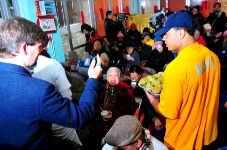US Navy 100219-N-4053P-124 Aviation Electronics Technician Dominque Lawson, assigned to the aircraft carrier USS Nimitz (CVN 68), serves food during a community service project at a senior citizen's home in Hong Kong. Nimitz is