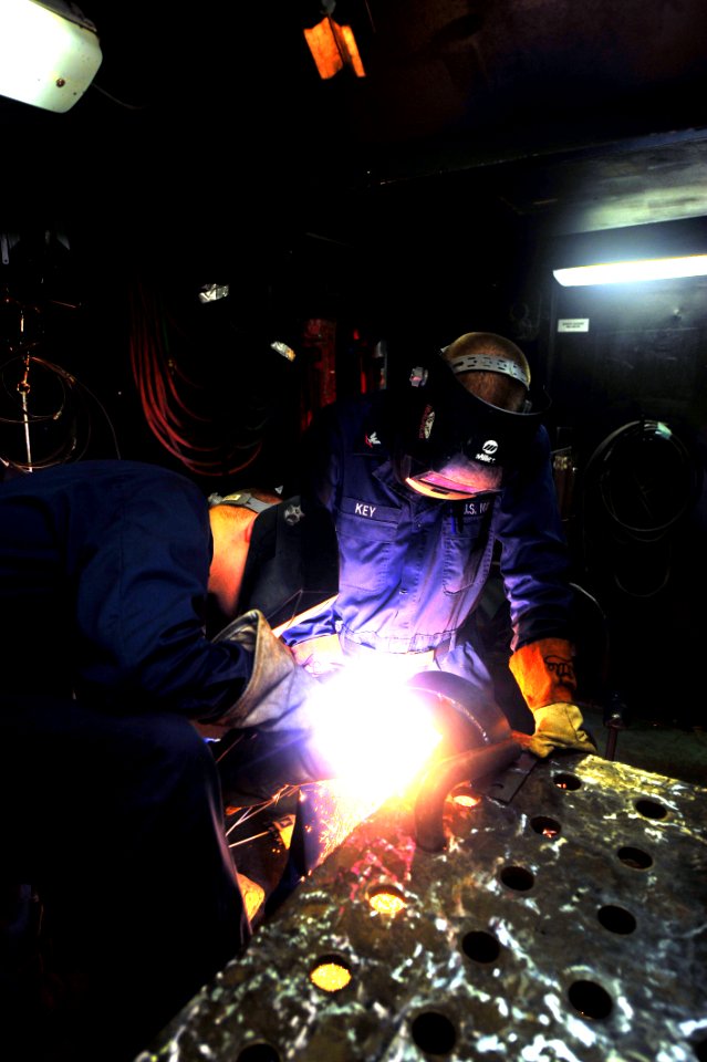 US Navy 100220-N-2953W-061 Hull Technician 2nd Class Dustin Grover and Hull Technician 3rd Class Brandon Key use a plasma cutter to cut a pipe bracket in the shipfitter and machine shop aboard USS Carl Vinson (CVN 70)