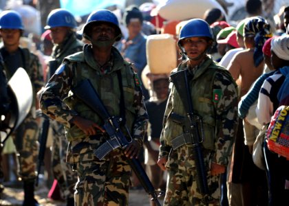 US Navy 100220-N-5961C-005 U.N. peacekeepers from Nepal stand by as Haitian citizens wait for rice at a distribution point in Kenscoff, Haiti