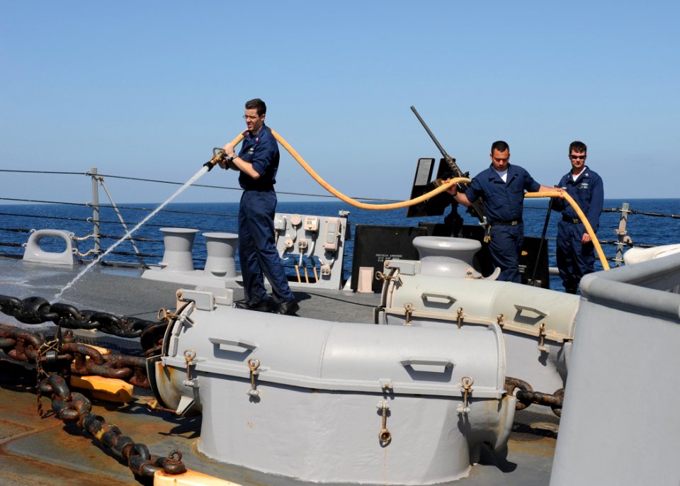 US Navy 100220-N-7088A-024 Fire Controlman 1st Class Phillip White, along with other Sailors stationed aboard the Arleigh Burke-class guided-missile destroyer USS Farragut (DDG 99), sprays down the forecastle