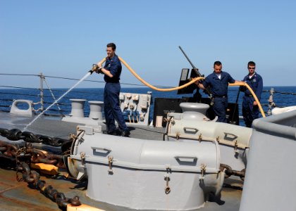 US Navy 100220-N-7088A-024 Fire Controlman 1st Class Phillip White, along with other Sailors stationed aboard the Arleigh Burke-class guided-missile destroyer USS Farragut (DDG 99), sprays down the forecastle