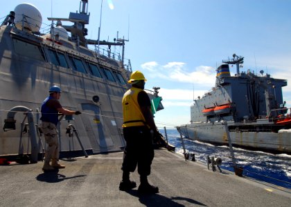US Navy 100220-N-7058E-381 Chief Logistics Specialist Keith Wilkerson, assigned to the littoral combat ship USS Freedom (LCS 1) signals the Military Sealift Command fleet replenishment oiler USNS Leroy Grumman