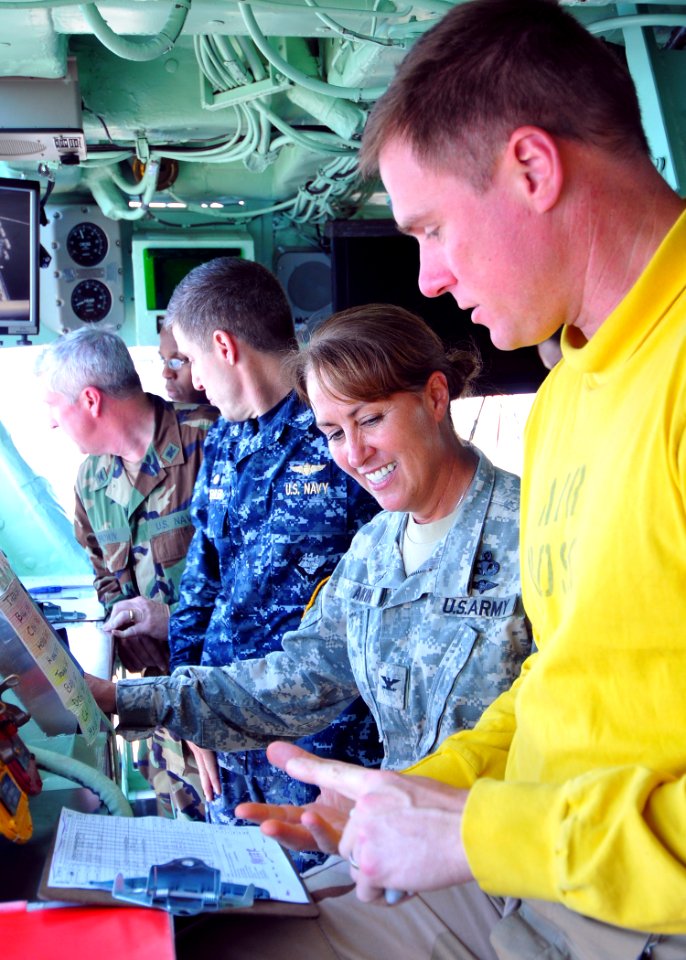 US Navy 100222-N-4649B-223 Cmdr. Dan Olson, air boss aboard the multipurpose amphibious assault ship USS Bataan (LHD 5), explains the day's air plan to Col. Robin Akin, commander of Joint Logistics Command
