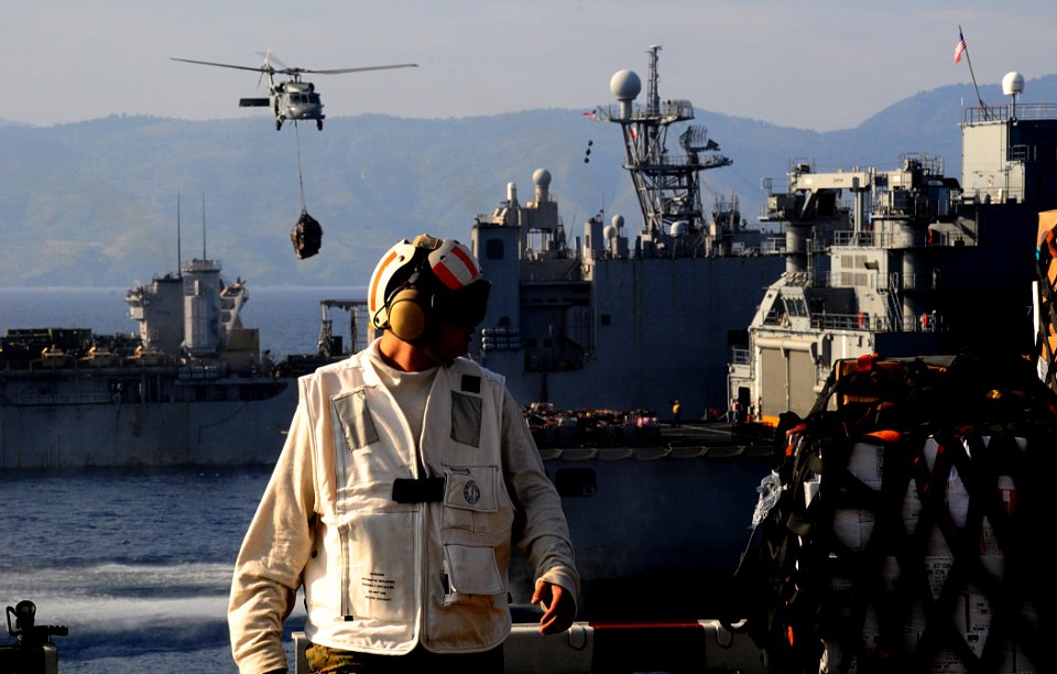 US Navy 100220-N-7508R-206 An MH-60S Sea Hawk helicopter transports supplies from the Military Sealift Command dry cargo ship USNS Sacagawea (T-AKE 2) to the multipurpose amphibious assault ship USS Bataan (LHD 5)