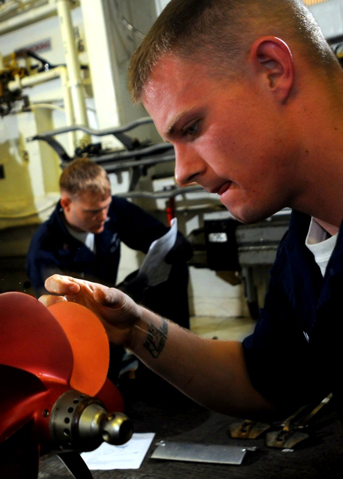 US Navy 100223-N-1688B-007 Gunner's Mate 3rd Class Cameron Massie prepares a torpedo for mounting on a helicopter aboard the guided-missile cruiser USS Hue City (CG 66)