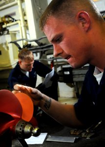 US Navy 100223-N-1688B-007 Gunner's Mate 3rd Class Cameron Massie prepares a torpedo for mounting on a helicopter aboard the guided-missile cruiser USS Hue City (CG 66)