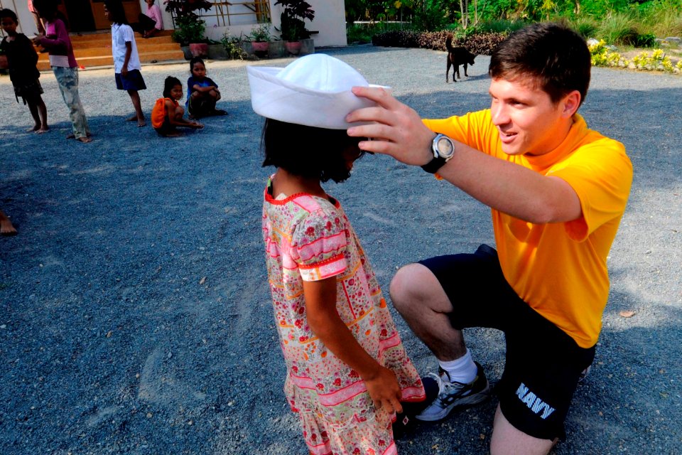 US Navy 100220-N-8335D-022 Mineman 3rd Class Jmyle Koretz, assigned to the mine counter-measures ship USS Patriot (MCM 7), gives a child his