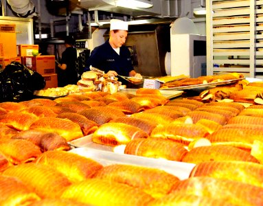US Navy 100223-N-7939W-011 Aviation Ordnanceman Seaman Megan Alascia wraps fresh slices of baked bread photo