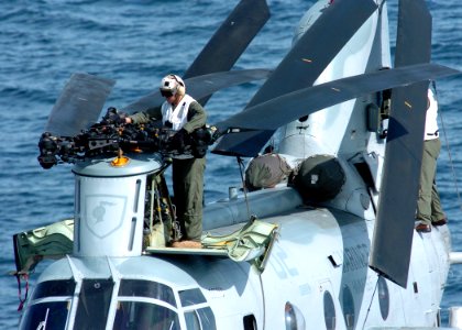 US Navy 100223-N-7948R-007 A member of the flight crew folds the wings of a CH-46 Sea Knight helicopter after flight operations aboard the amphibious assault ship USS Peleliu (LHA 5)