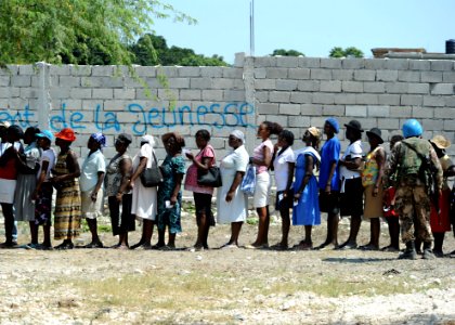 US Navy 100224-N-5961C-007 Haitian women queue to receive plastic sheeting and water