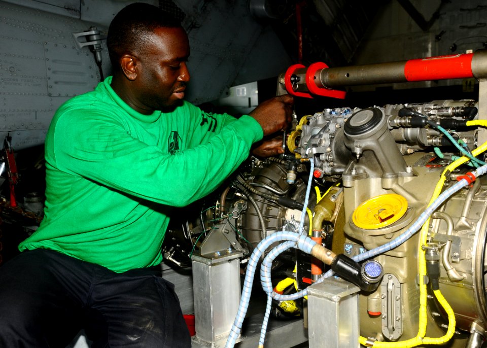 US Navy 100222-N-1092P-002 Aviation Structural Mechanic 2nd Class Pierre Doreus, assigned to Helicopter Sea Combat Squadron (HSC) 26, conducts maintenance on the engine of an MH-60S Sea Hawk helicopter