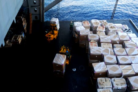 US Navy 100225-N-3038W-001 Sailors assigned to USS Nimitz (CVN 68) transport supplies from an aircraft elevator into the ship's hangar bay