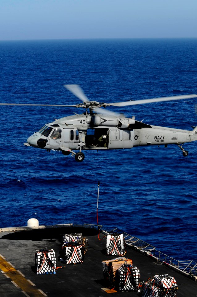 US Navy 100222-N-2735T-054 An MH-60S Sea Hawk helicopter drops supplies onto the flight deck of USS Nassau (LHA 4)