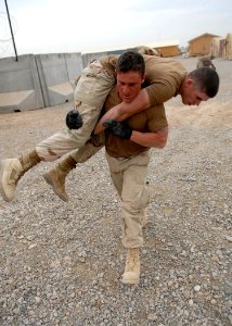 US Navy 100226-N-4440L-102 Equipment Operator 2nd Class Christopher McAvoy fireman-carries Construction Mechanic Construction Recruit Morgan Pierce while participating in the Marine Corps Martial Arts Program photo