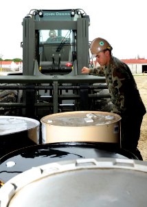 US Navy 100226-N-6357K-001 Equipment Operator 3rd Class AJ Dunn directs Equipment Operator Constructionman Apprentice Tyler Martin as he operates a 12K forklift to load materials