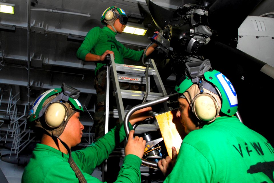 US Navy 100223-N-3327M-060 Sailors assigned to (VAW) 117 service a propeller of an E-2C Hawkeye