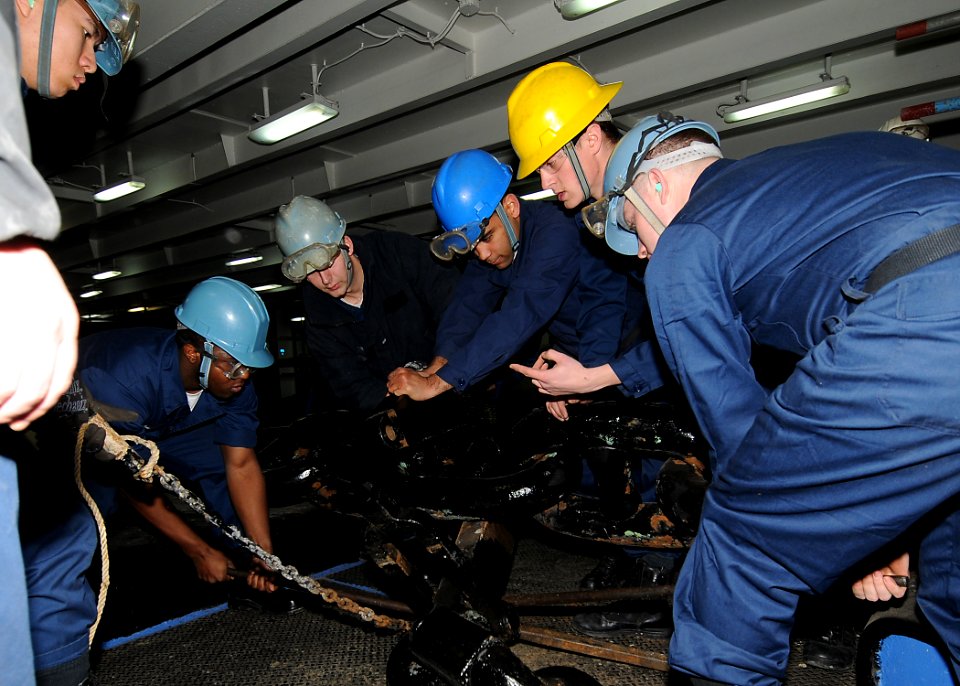 US Navy 100224-N-6233H-028 Deck department Sailors aboard the aircraft carrier USS George Washington (CVN 73) attach a pelican hook to an anchor chain in the forecastle