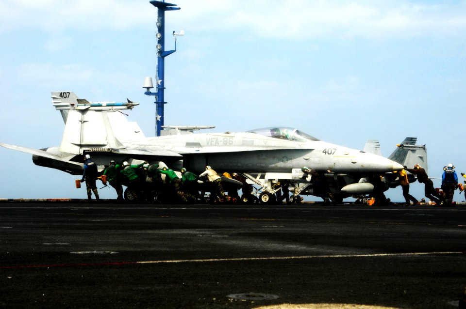US Navy 100227-N-3038W-346 Flight deck personnel push back an F-A-18C Hornet aboard USS Nimitz (CVN 68)