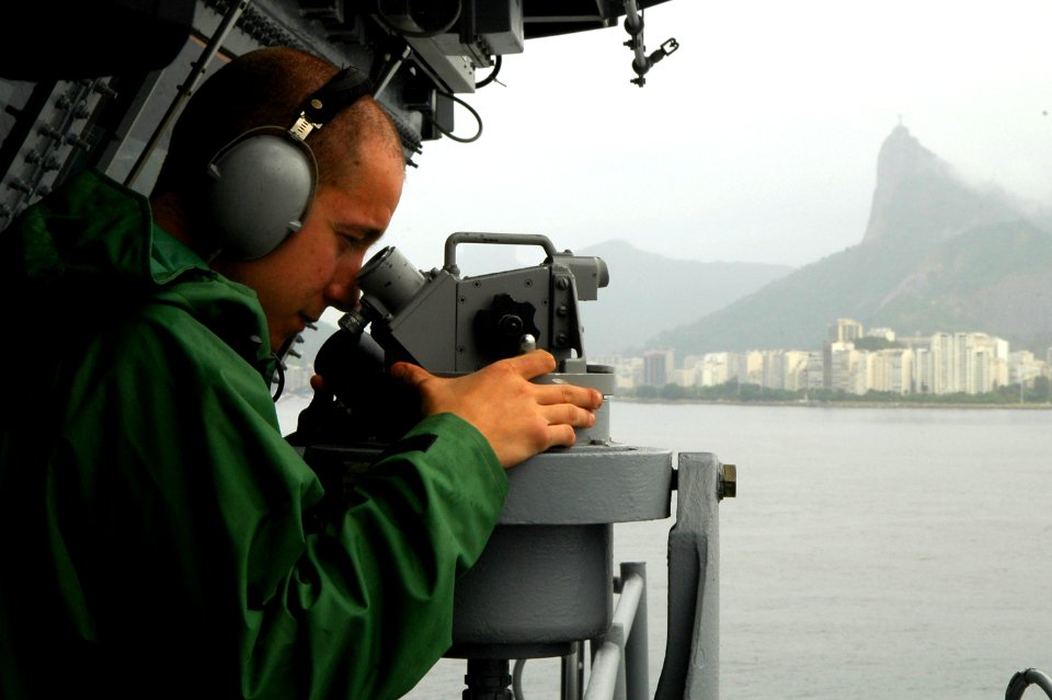 US Navy 100226-N-8822R-235 Quartermaster 3rd Class Daniel Gastaldi measures the distance of checkpoints as the aircraft carrier USS Carl Vinson (CVN 70) prepares to anchor off the coast of Rio de Janeiro, Brazil