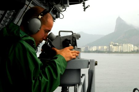 US Navy 100226-N-8822R-235 Quartermaster 3rd Class Daniel Gastaldi measures the distance of checkpoints as the aircraft carrier USS Carl Vinson (CVN 70) prepares to anchor off the coast of Rio de Janeiro, Brazil